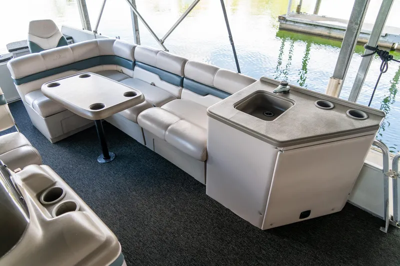 Slide: The Image of Interior of 2000 Sun Tracker Fishin' Barge 25 with seating, table, and sink. - 11