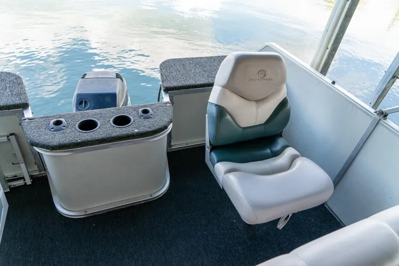 Slide: The Image of 2000 Sun Tracker Fishin' Barge 25 interior with seating and motor, on calm water. - 15