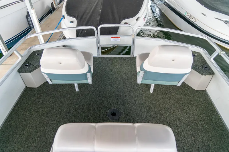 Slide: The Image of 2000 Sun Tracker Fishin' Barge 25 interior with seating and fishing setup. - 23