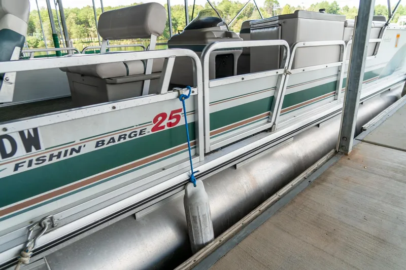 Slide: The Image of 2000 Sun Tracker Fishin' Barge 25 pontoon boat docked, side view with seating. - 5