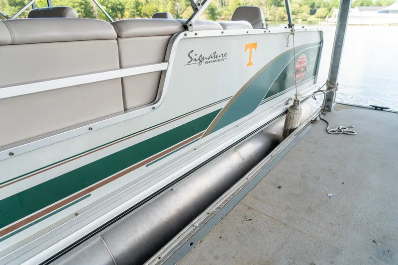 Slide: The Image of 2000 Sun Tracker Fishin' Barge 25 pontoon boat docked, featuring green and white design. - 6