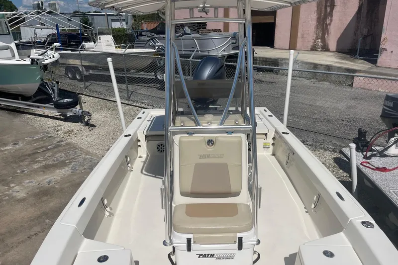 Slide: The Image of 2016 Pathfinder 2200 TRS boat with center console and seating, parked outdoors. - 10