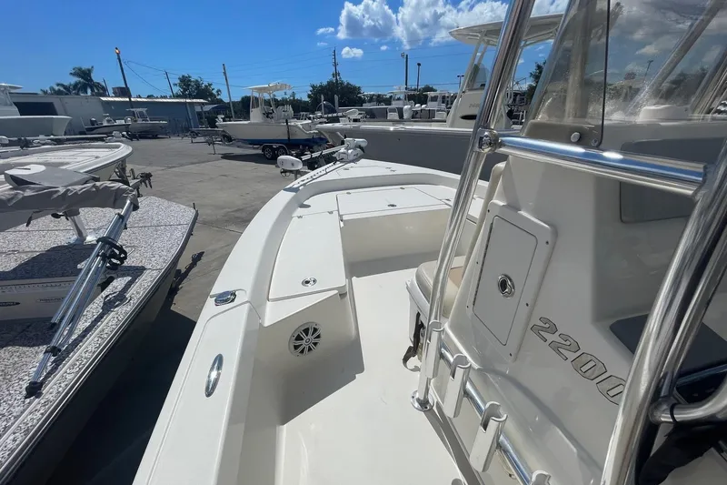 Slide: The Image of 2016 Pathfinder 2200 TRS boat in a marina, showcasing sleek design and spacious deck. - 7