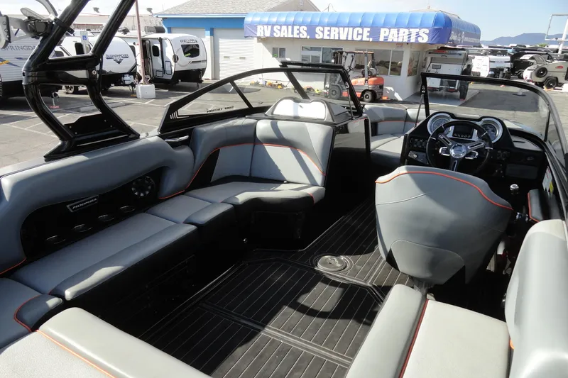 Slide: The Image of 2017 Moomba Craz boat interior with gray seating, black flooring, and modern dashboard. - 14