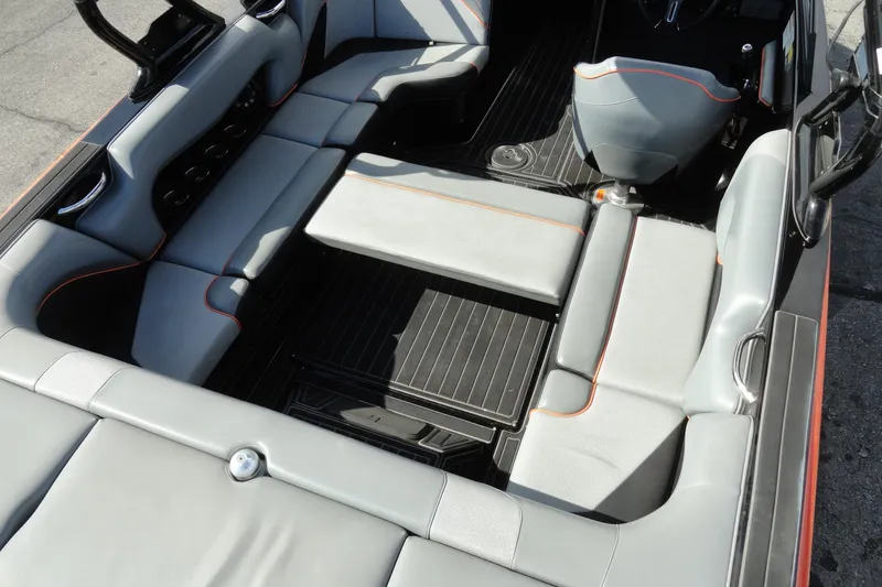 Slide: The Image of 2017 Moomba Craz boat interior with gray seating and orange accents. - 18
