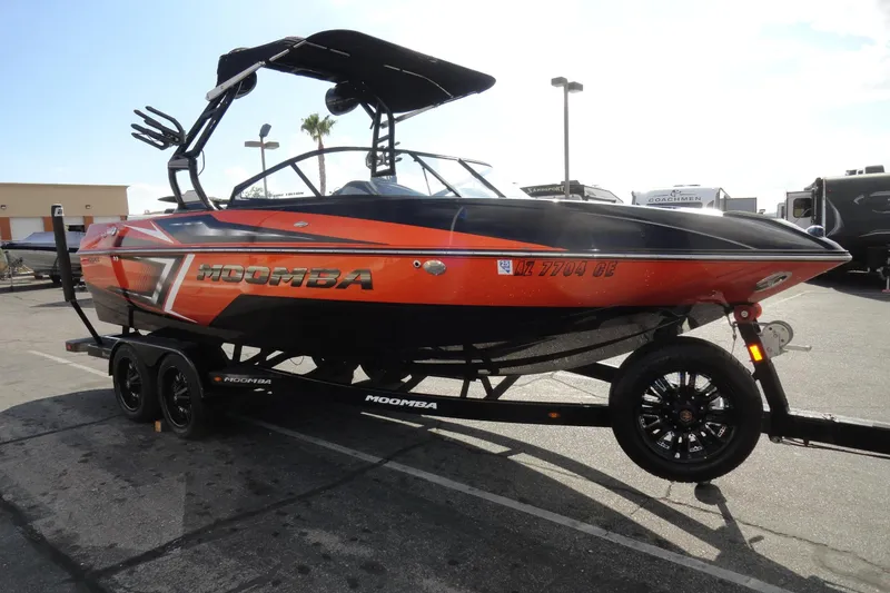 Slide: The Image of 2017 Moomba Craz boat on trailer, vibrant orange and black design, parked outdoors. - 4