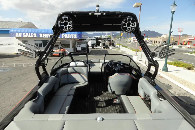 Slide: The Image of 2017 Moomba Craz boat interior with seating and wakeboard tower in a dealership lot. - 6