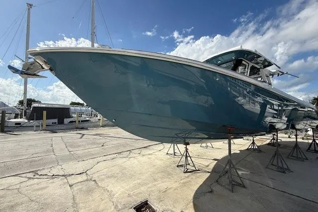 Slide: The Image of 2026 Solace 37 CS boat on stands, blue hull, sunny day, marina background. - 1