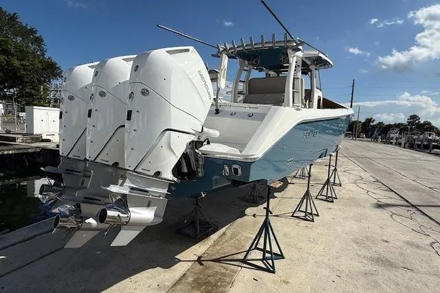 Slide: The Image of 2026 Solace 37 CS boat with triple outboard engines on a dry dock. - 2