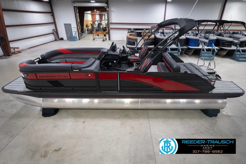 The Image of 2026 Bennington 24 MSB pontoon boat in showroom, featuring sleek red and black design. - 0