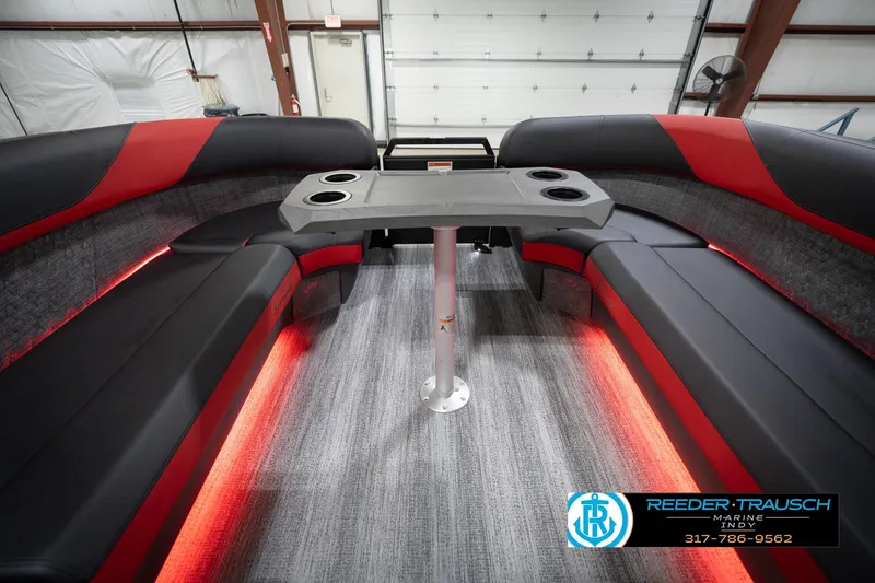 Slide: The Image of 2026 Bennington 24 MSB boat interior with red and black seating, table, and ambient lighting. - 19