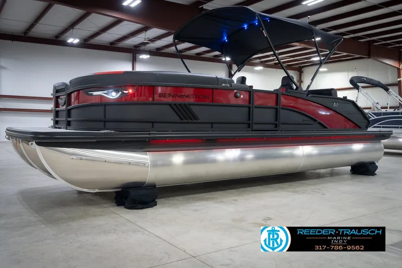 Slide: The Image of 2026 Bennington 24 MSB pontoon boat in showroom with canopy and sleek design. - 2