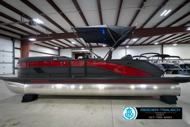 Slide: The Image of 2026 Bennington 24 MSB pontoon boat in showroom, featuring sleek red and black design. - 9