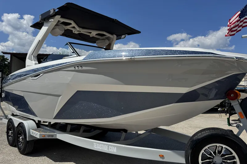 Slide: The Image of 2026 Tigé Z3 boat on trailer, sleek design, under clear blue sky. - 19