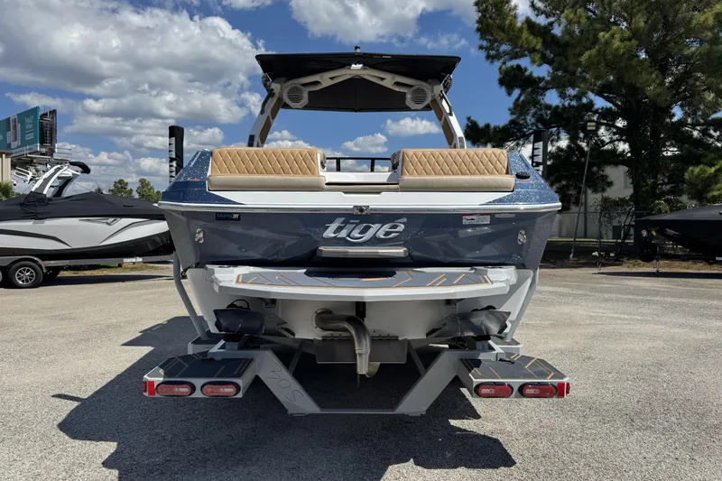 Slide: The Image of 2026 Tigé Z3 boat, rear view, parked outdoors under a partly cloudy sky. - 3