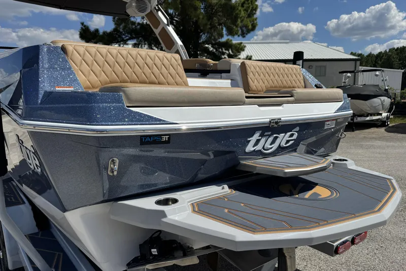Slide: The Image of 2026 Tigé Z3 boat with luxurious seating and sleek design, parked outdoors under a blue sky. - 6