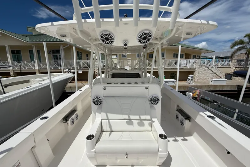 Slide: The Image of 2024 SeaVee 390Z boat interior with seating and speakers, docked at marina. - 12