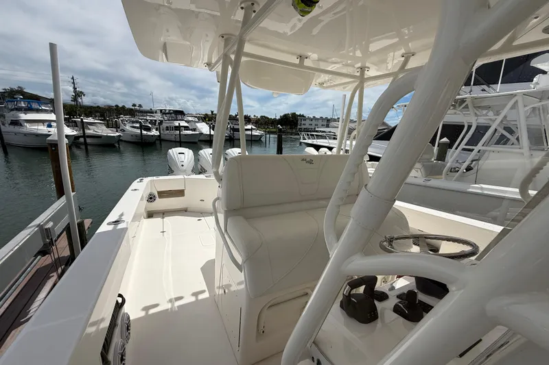 Slide: The Image of 2024 SeaVee 390Z boat interior at marina, showcasing seating and controls. - 14