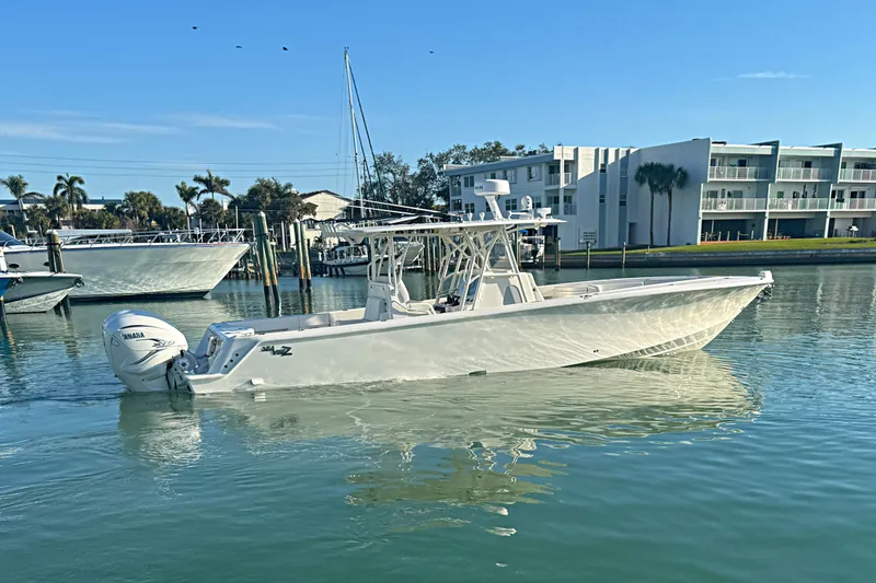 Slide: The Image of 2024 SeaVee 390Z boat on calm water near modern buildings. - 19