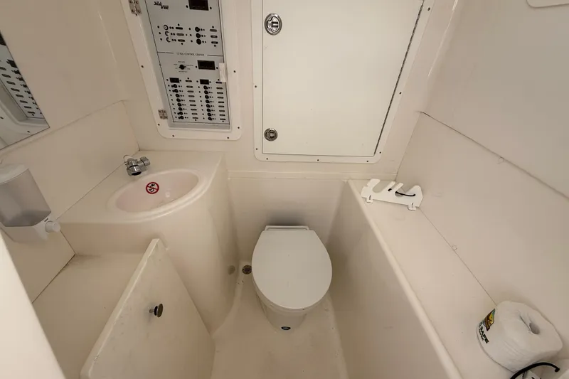 Slide: The Image of 2024 SeaVee 390Z boat bathroom with toilet, sink, and control panel. - 7