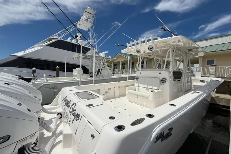 Slide: The Image of 2024 SeaVee 390Z boat docked, featuring multiple outboard engines and a spacious deck. - 8