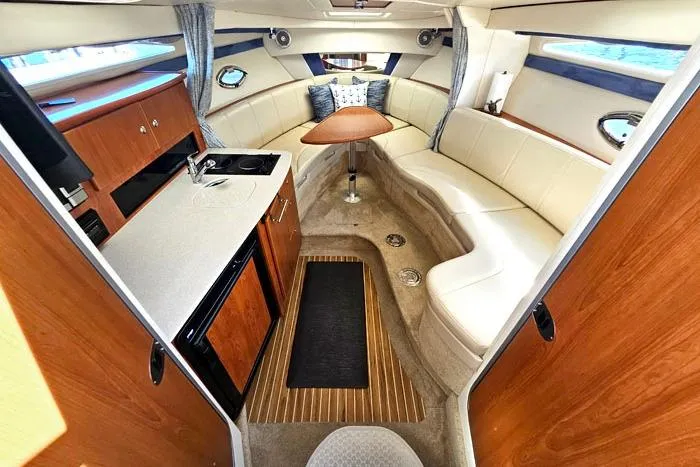 Slide: The Image of Luxurious interior of a 2008 Bayliner 320 boat with kitchenette and seating area. - 11