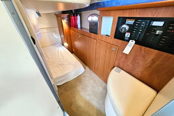 Slide: The Image of Interior of a 2008 Bayliner 320 boat, featuring a cozy cabin with wood paneling. - 19