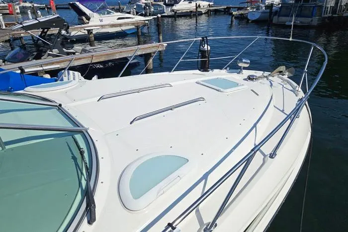 Slide: The Image of 2008 Bayliner 320 boat docked at marina, featuring sleek white deck and railings. - 2