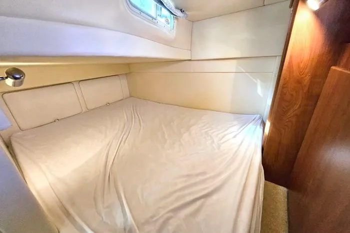 Slide: The Image of Interior cabin of a 2008 Bayliner 320 boat with a neatly made bed. - 20