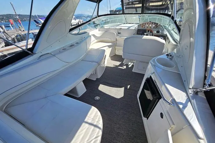 Slide: The Image of 2008 Bayliner 320 boat interior with white seating and helm, docked at marina. - 4