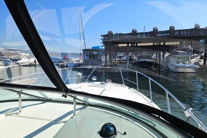 Slide: The Image of 2008 Bayliner 320 boat docked at marina, viewed from cockpit, clear blue sky. - 7