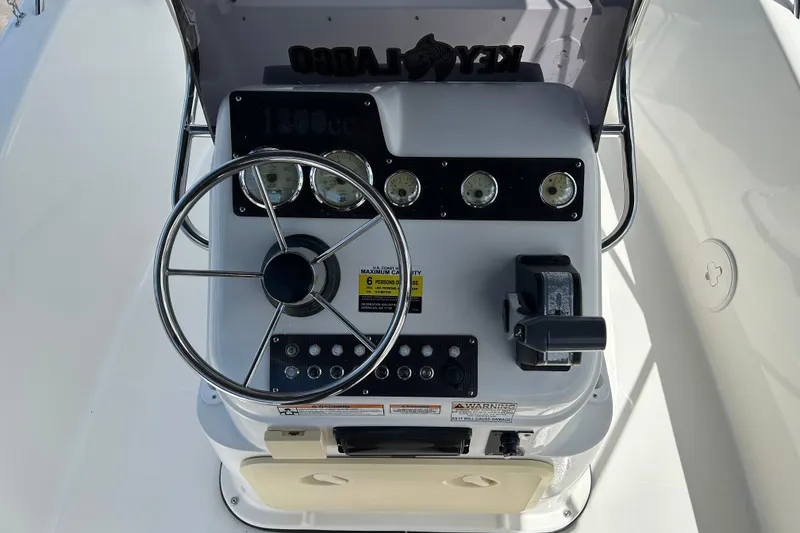 Slide: The Image of 2022 Key Largo 1800 Center Console boat dashboard with steering wheel and gauges. - 12