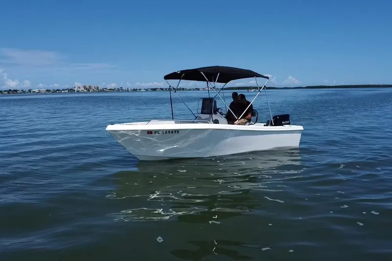Slide: The Image of 2022 Key Largo 1800 Center Console boat on calm water under clear blue sky. - 16