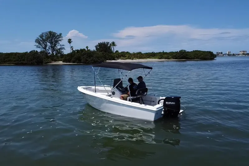Slide: The Image of 2022 Key Largo 1800 Center Console boat cruising near a scenic island. - 17