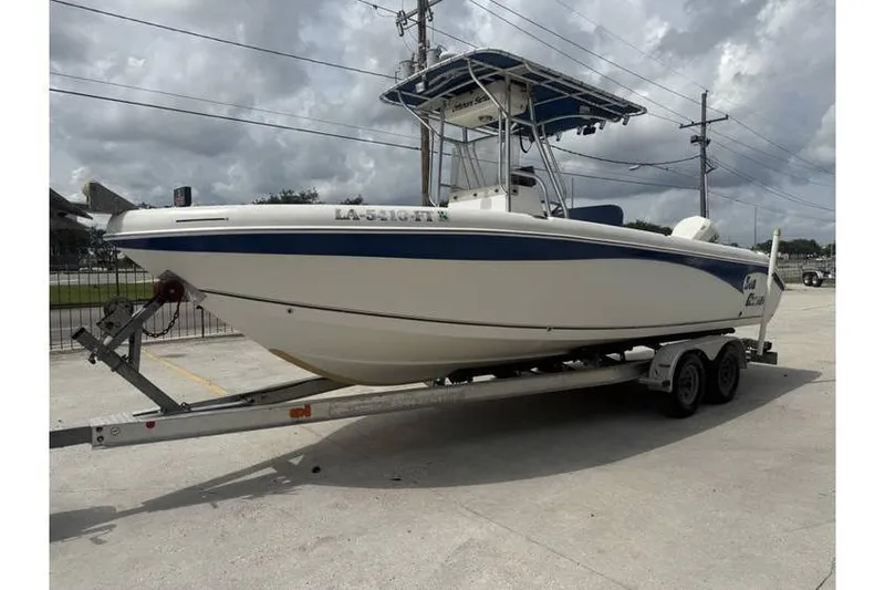 Slide: The Image of 2008 Sea Chaser 2400 CC boat on trailer, parked outdoors under cloudy sky. - 2