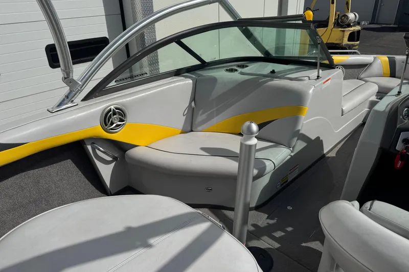 Slide: The Image of 2008 Moomba Mobius LS boat interior with gray and yellow seating, near a garage. - 10