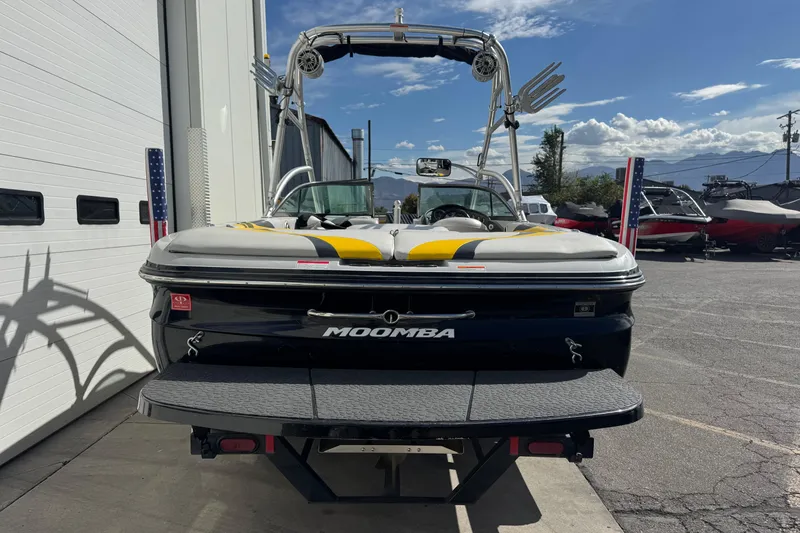 Slide: The Image of 2008 Moomba Mobius LS boat parked outside, featuring a sleek design and vibrant upholstery. - 2