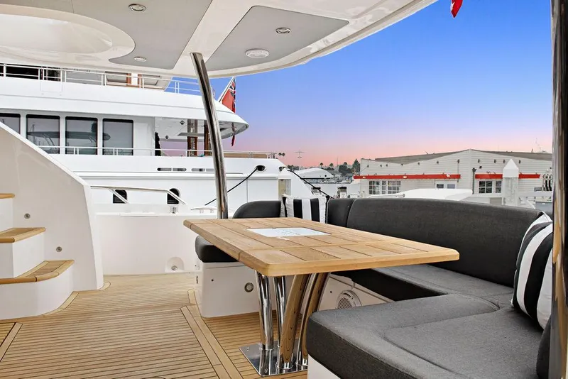 Slide: The Image of Luxurious 2016 Sunseeker 75 Yacht deck with elegant seating and wooden table at sunset. - 30