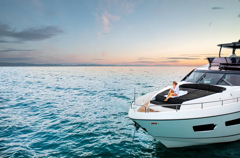Slide: The Image of 2016 Sunseeker 75 Yacht cruising at sunset with person relaxing on deck. - 7