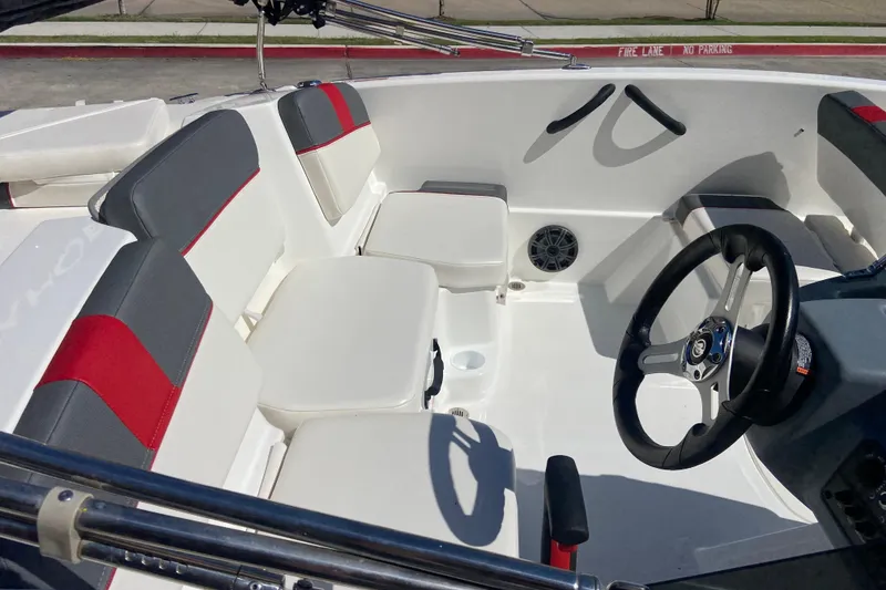 Slide: The Image of 2023 Tahoe T16 boat interior with red and gray seating, steering wheel, and speaker. - 4