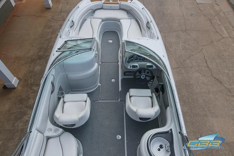Slide: The Image of 2004 Crownline 240 EX boat interior with white seating and dashboard, viewed from above. - 12