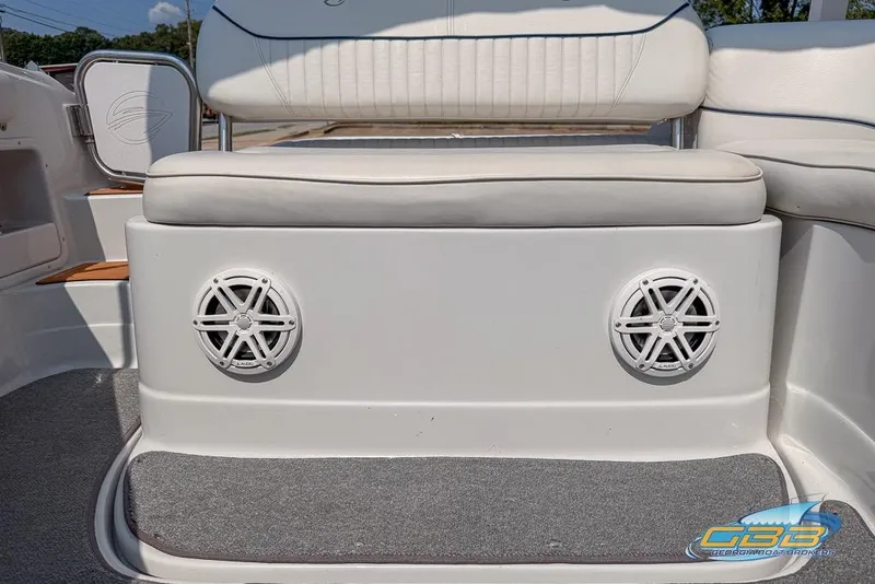 Slide: The Image of 2004 Crownline 240 EX boat interior with white seating and dual speakers. - 26