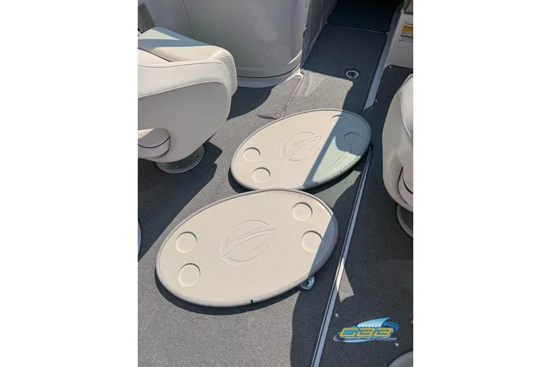 Slide: The Image of 2004 Crownline 240 EX boat interior with beige seating and oval floor covers. - 31