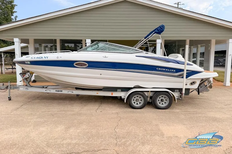 Slide: The Image of 2004 Crownline 240 EX boat on trailer, parked outside a building. - 7