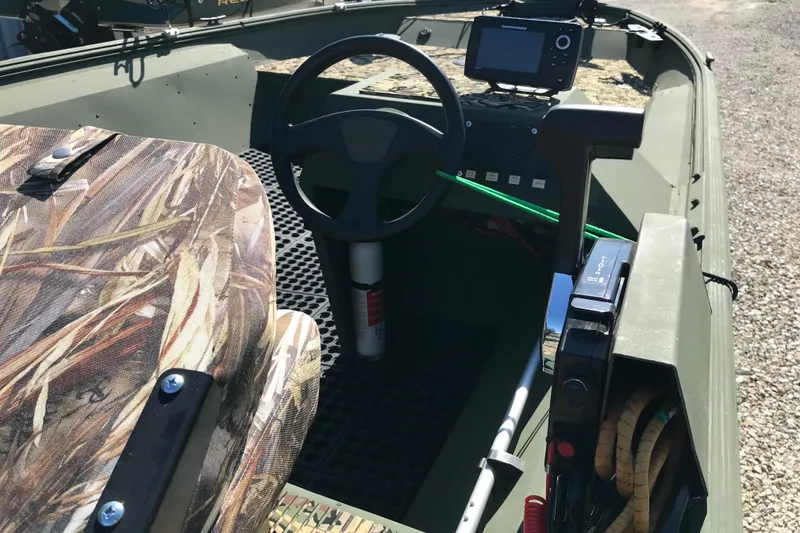 Slide: The Image of Interior of a 2001 Lowe Roughneck 1860SC boat with camouflage seating and steering console. - 11