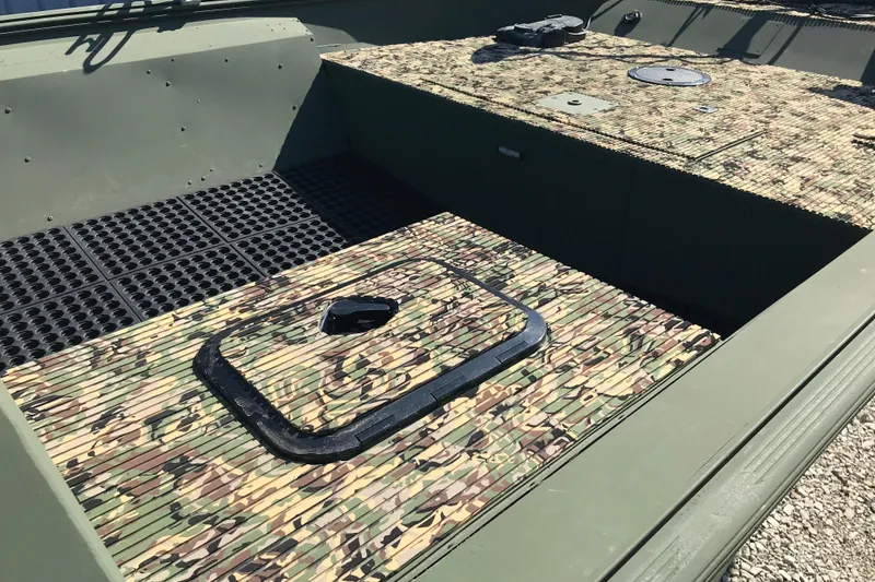 Slide: The Image of 2001 Lowe Roughneck 1860SC boat interior with camouflage flooring and storage hatch. - 12