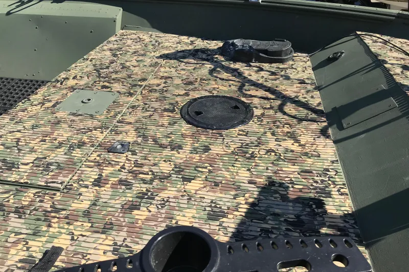 Slide: The Image of Camouflage deck of 2001 Lowe Roughneck 1860SC boat with storage compartments. - 13