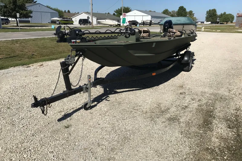 Slide: The Image of 2001 Lowe Roughneck 1860SC boat on trailer, parked on gravel driveway. - 6