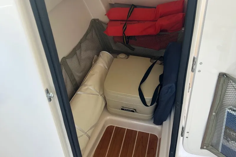 Slide: The Image of 2013 Grady-White Freedom 255 boat storage area with life jackets and cooler. - 7