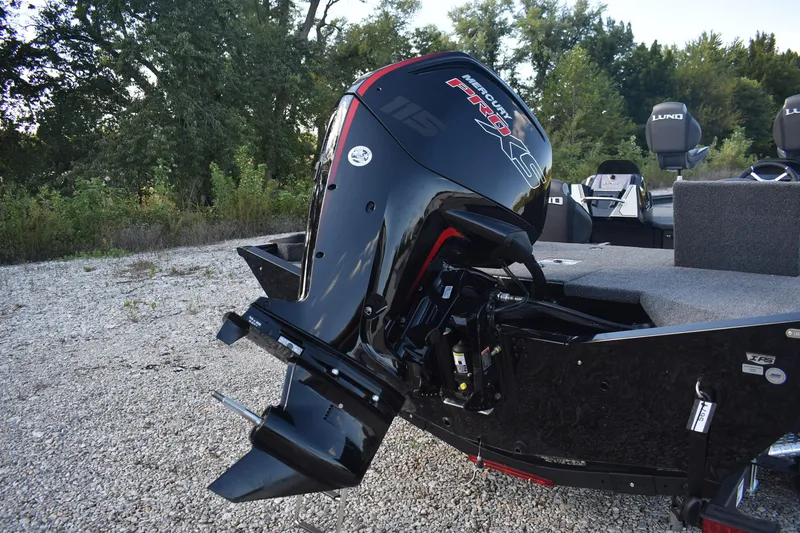 Slide: The Image of 2026 Lund 1875 Renegade boat ladder on gravel, showcasing rear design and trailer. - 8